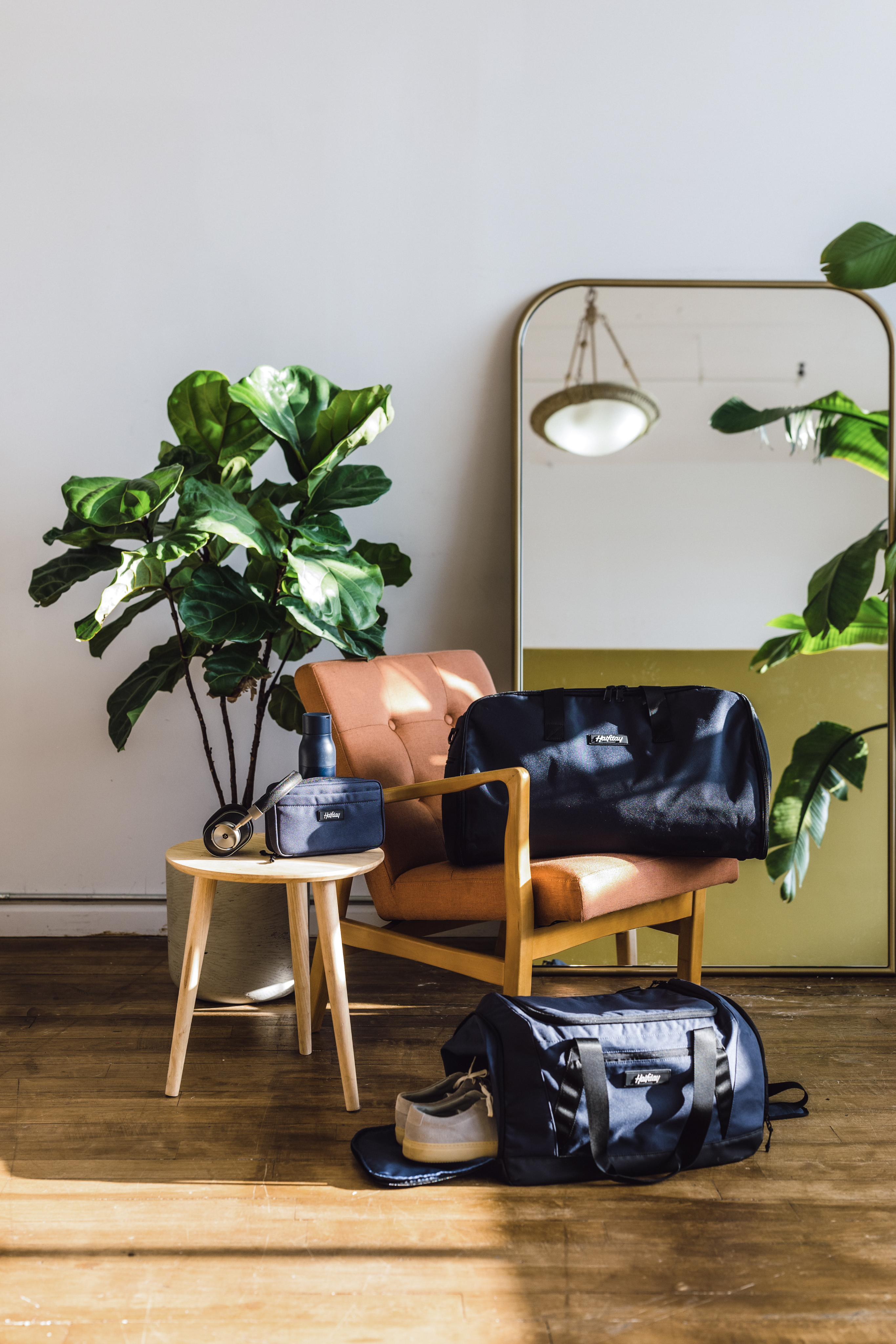 Halfday Duffel bags and accessories sitting on a living room setting